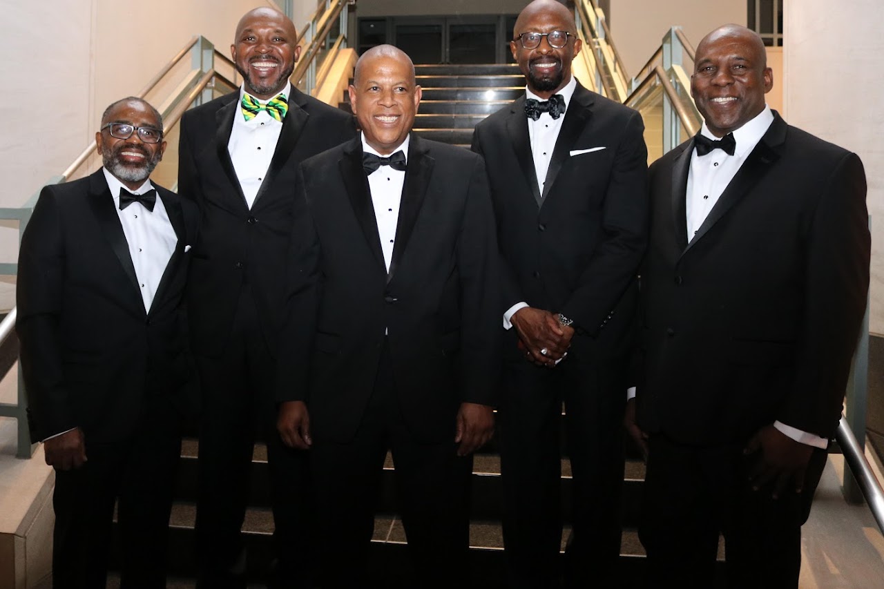 A group of men in tuxedos standing next to each other.